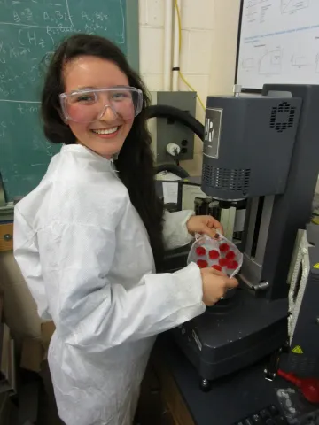 Carolina conducting research in white lab coat
